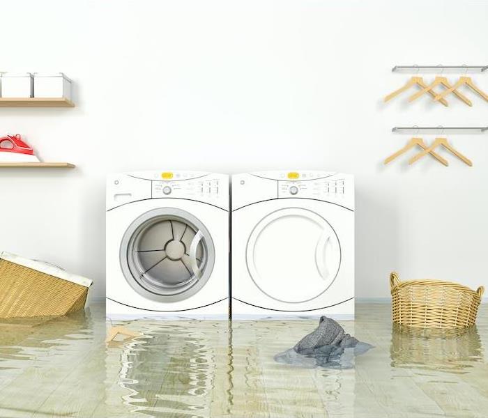 Room with water covering the floor and a white washer and dryer