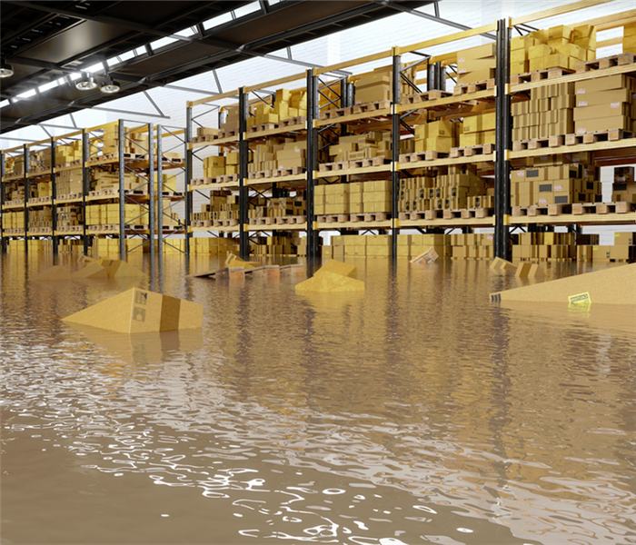 a flooded storage building with boxes floating through the water